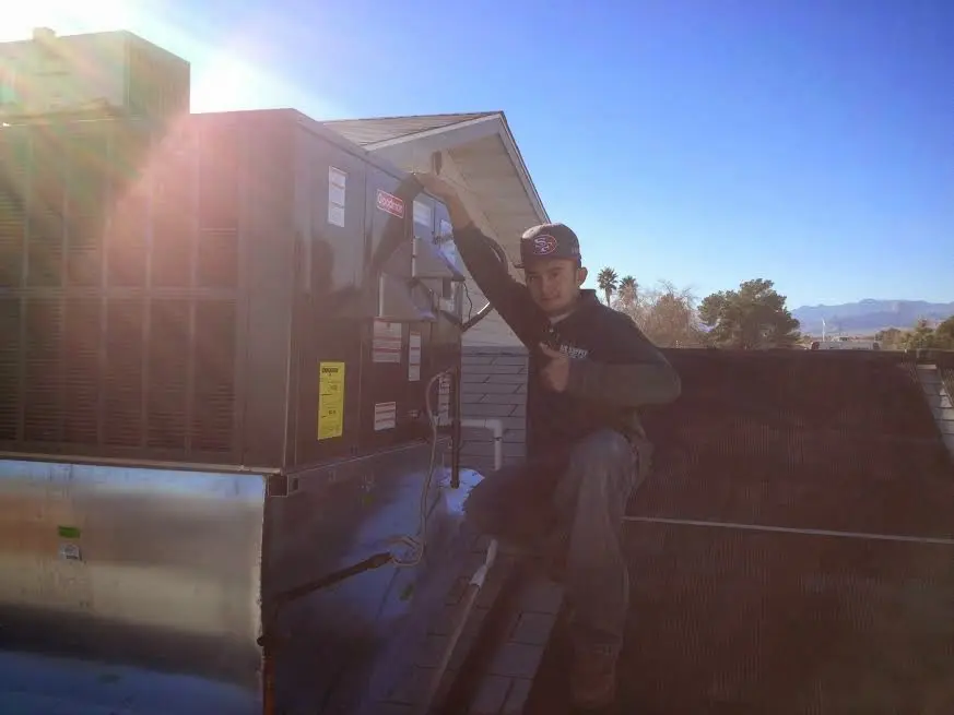 HVAC technician performing Boiler Repair on a rooftop unit in Cameron